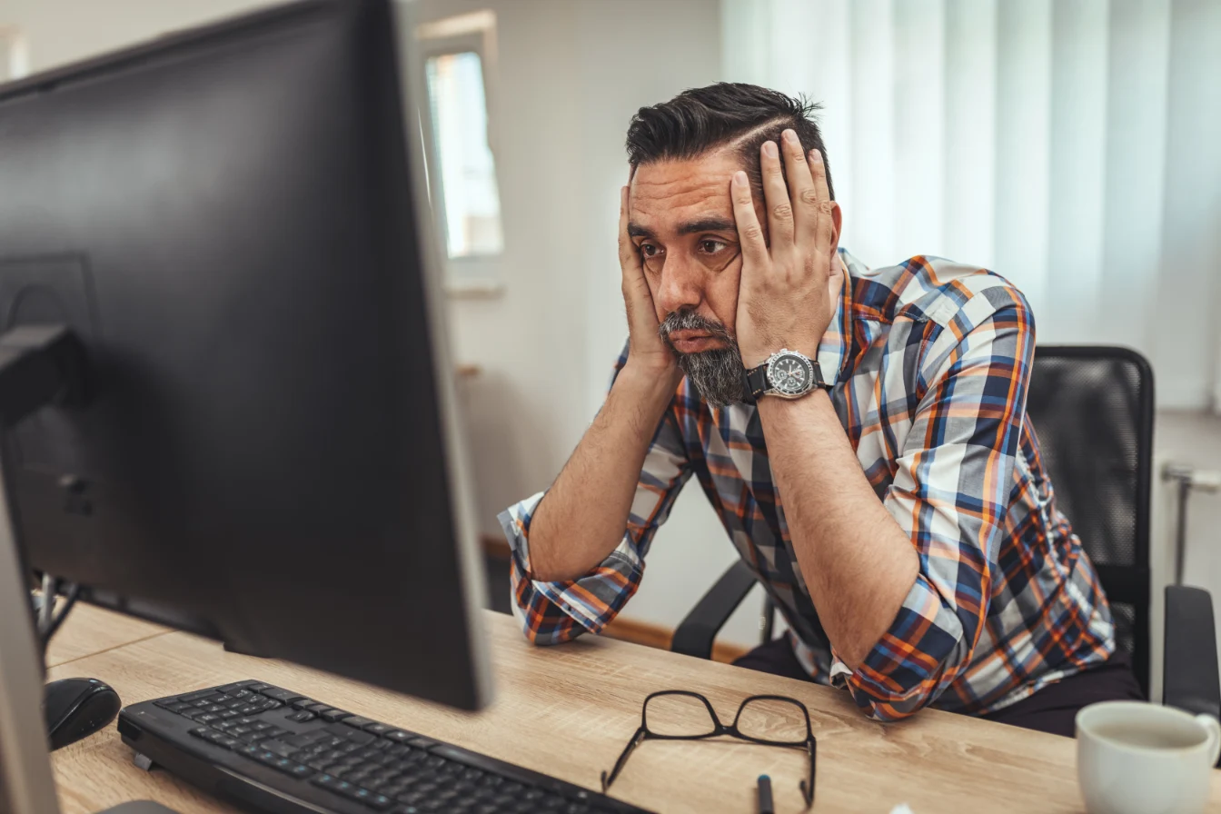 Zmartwioy mężczyzna przed stroną internetową